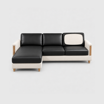 L-shaped sofa with black PU leather covers on its seat, chaise and back cushions, one back cushion turned to show the elastic underside, on a light gray background