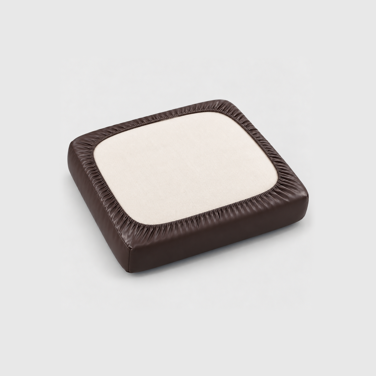 Underside of a seat cushion in a brown PU leather cover, the elastic hem gathered all around the cream cushion fabric