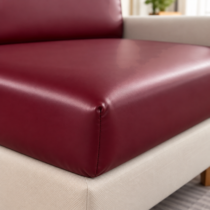 Close view of the front corner of a burgundy PU leather cushion cover, with its sewn corner seam and soft sheen