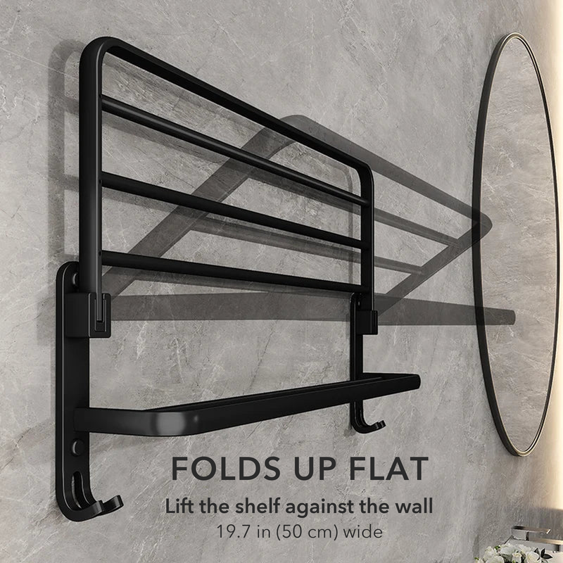 Matte black towel rack with its top shelf folded up flat against the wall, captioned folds up flat, 19.7 inches wide
