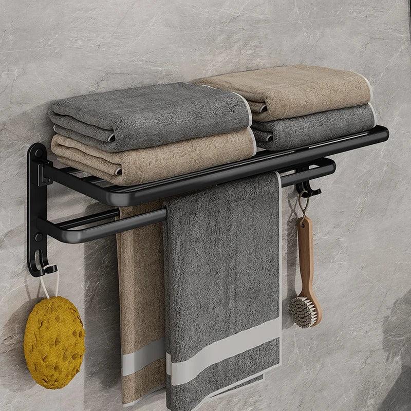 Matte black towel rack seen from the front with two stacks of folded towels on top and a towel hanging from the bar
