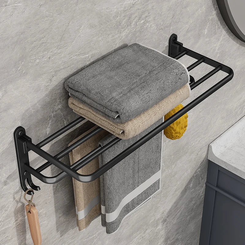 Matte black towel rack seen from the left beside a basin, with towels on the shelf and bar and a brush and sponge on its hooks