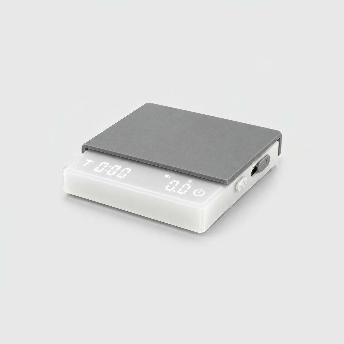 White coffee scale with a frosted white body and gray silicone mat, the display lit, on a light gray studio background