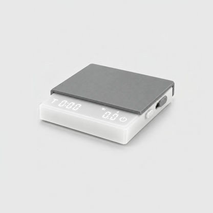 White coffee scale with a frosted white body and gray silicone mat, the display lit, on a light gray studio background