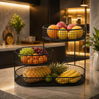 Black three tier fruit stand filled with fruit on a kitchen counter in the evening