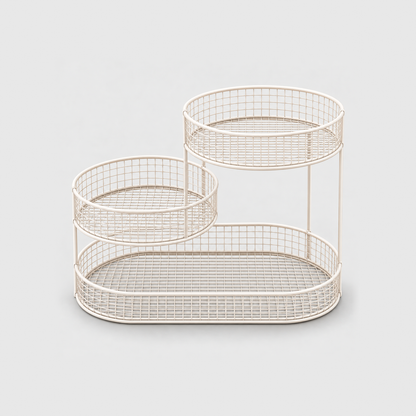 The white three tier fruit stand empty, showing the wire grid floors and the slim upright rods, on a plain light gray background