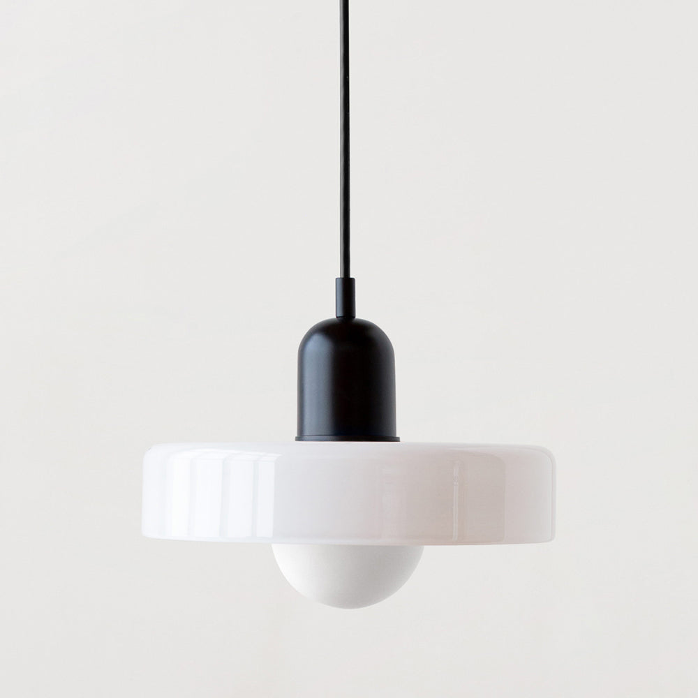 Bauhaus pendant light with a white glass ring shade and a black metal body on a light gray background