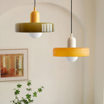 An olive shade on a yellow body and an amber shade on a beige body hanging at two heights by an arched wall