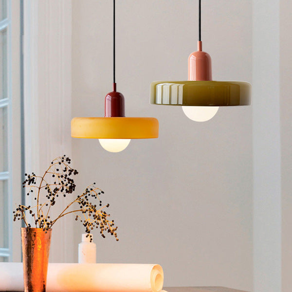 An amber shade on a burgundy body and an olive shade on a pink body over a table with dried flowers
