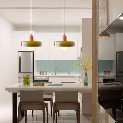 Two olive glass pendants with pink bodies over a white kitchen island