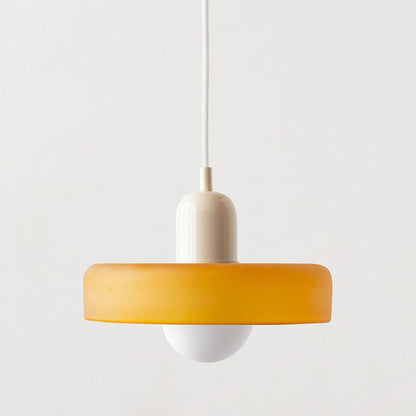 Bauhaus pendant light with a matte amber glass ring shade, a beige body and a white cord