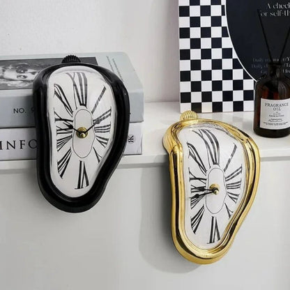 A black melting clock and a gold melting clock draped over the edge of a white shelf beside a stack of books