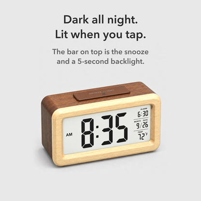 Brown wooden alarm clock seen from above with the snooze and light bar on top and the screen lit, with the words Dark all night, lit when you tap