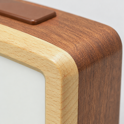 Close-up of the brown alarm clock's corner, where the pale wood front frame meets the reddish-brown wood body