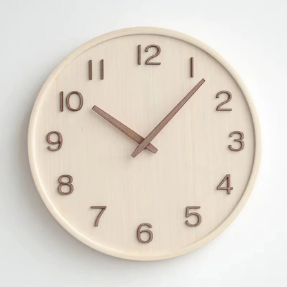 Natural wood wall clock seen straight on, with raised walnut numbers 1 to 12 and two slim walnut hands
