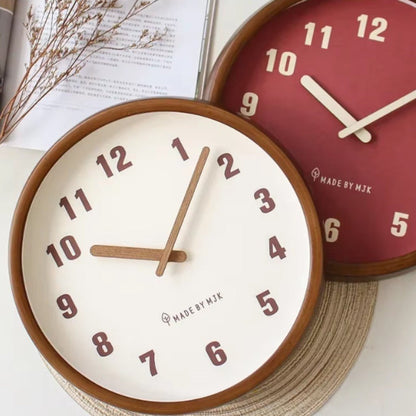 The White and Red wall clocks lying together beside an open book and a sprig of dried flowers