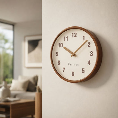 The White wall clock on a cream wall beside an open living room with a window and a framed print