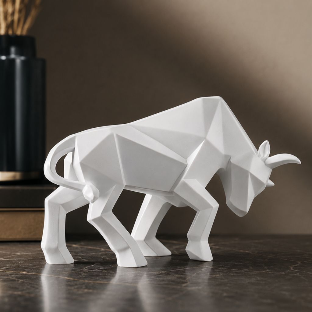 A white faceted bull sculpture facing right on a dark marble shelf
