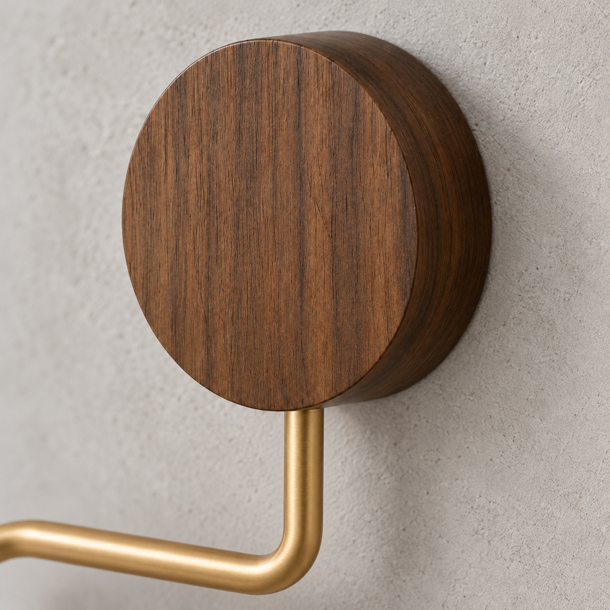 Close-up of the walnut wood disc and the brushed gold arm of the toilet paper holder
