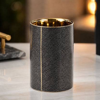 Black ceramic tumbler with cream dots, a gold-coated rim and a gold-coated inside
