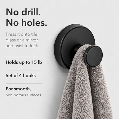 Black suction wall hook holding a gray hand towel on a plain wall, captioned No drill. No holes.
