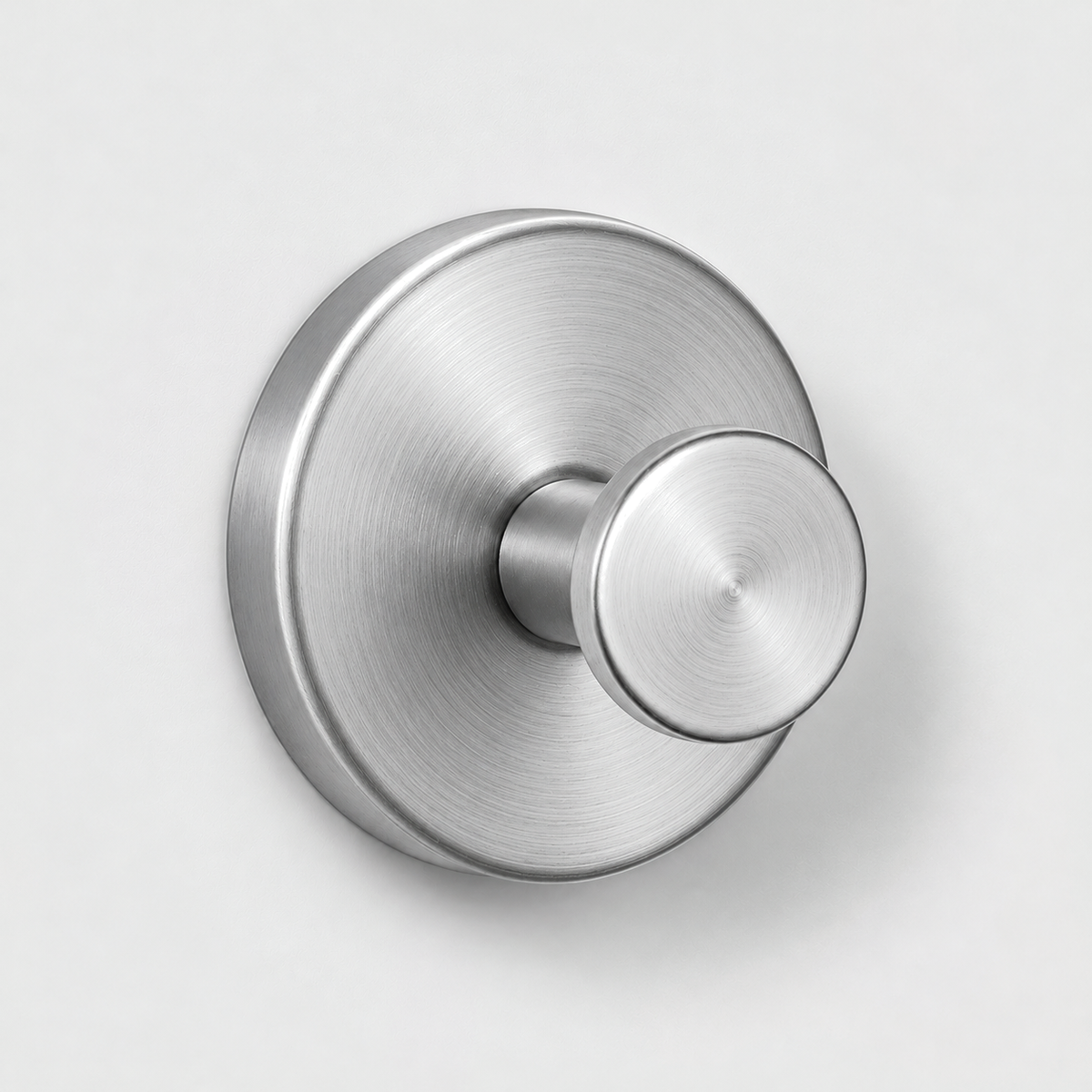 Brushed silver suction cup wall hook on a light gray wall