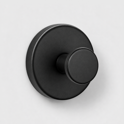 Black suction cup wall hook on a light gray wall