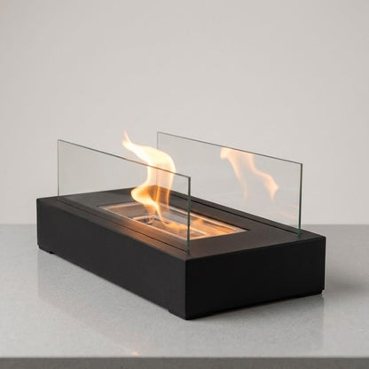 Lit tabletop fire pit on a pale gray counter against a plain wall