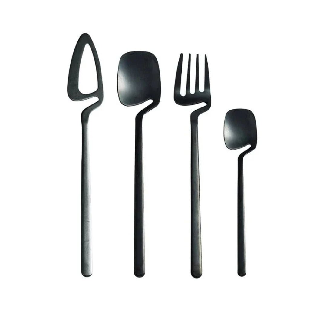 Black flatware set: open-blade knife, spoon, four-tine fork and teaspoon standing upright on white