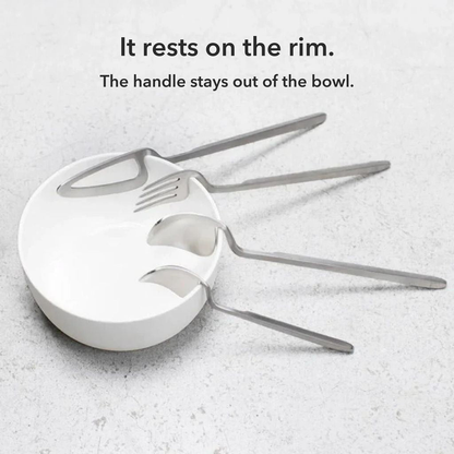 Silver knife, fork, spoon and teaspoon resting on the rim of a white bowl, with the words It rests on the rim