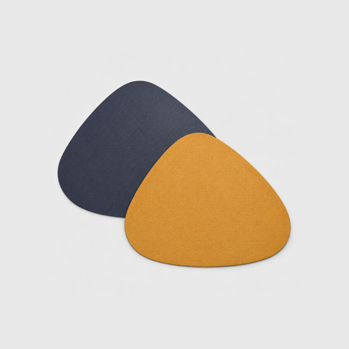 Two reversible PU leather placemats in Blue and Yellow, one showing the navy side and one the mustard yellow side