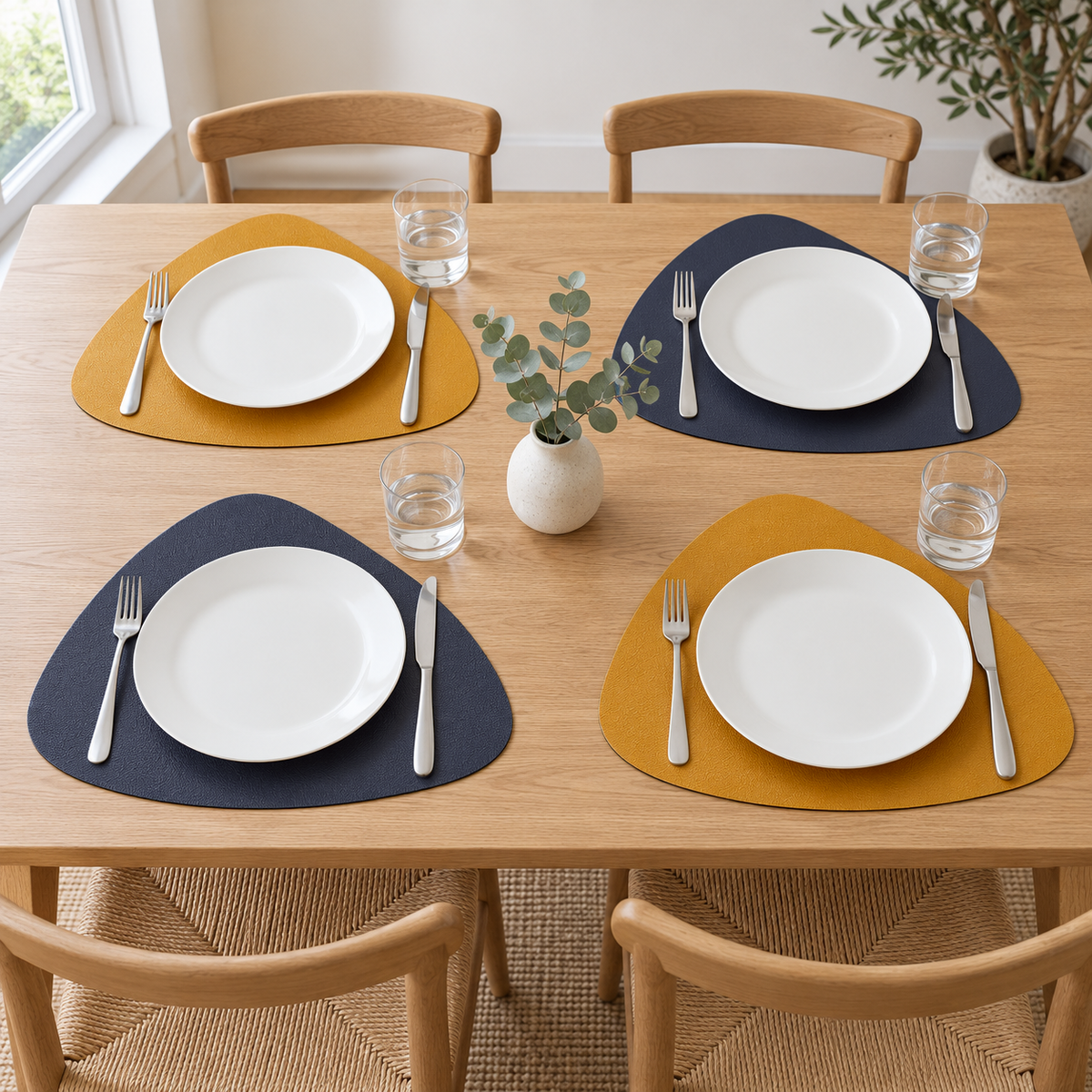 Four Blue and Yellow placemats on an oak dining table, alternating navy and mustard sides, in daylight