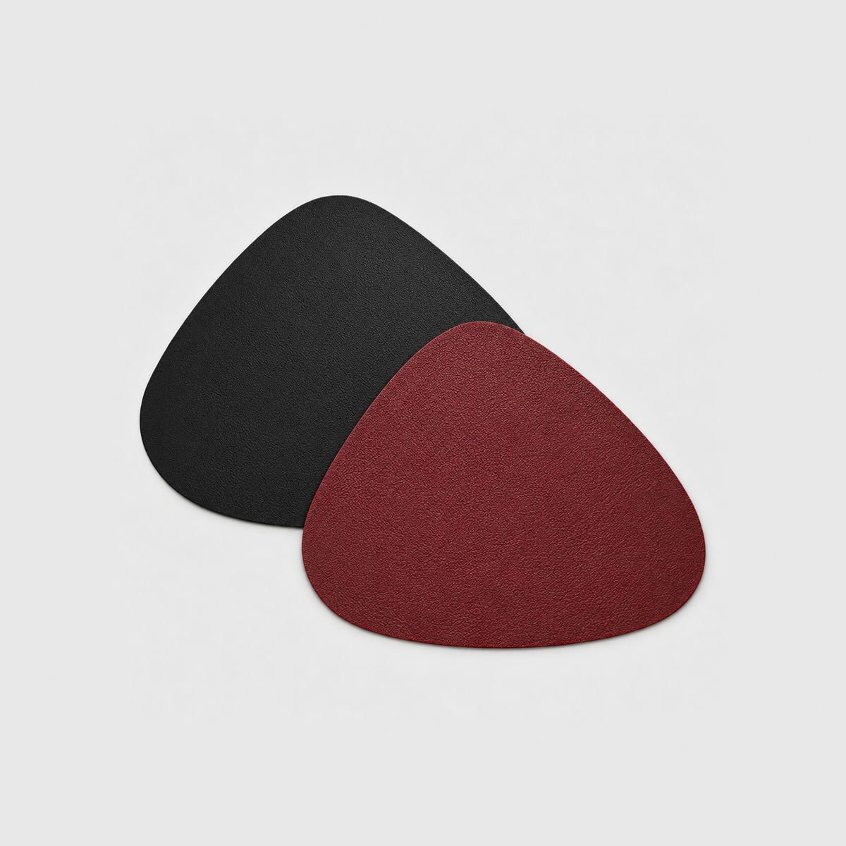 Two reversible placemats in Burgundy and Black, one showing the burgundy side and one the black side