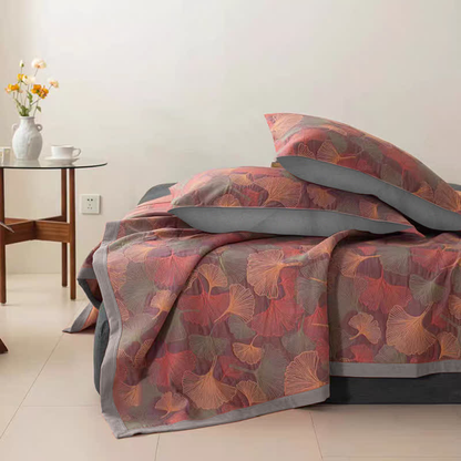 Rose ginkgo leaf quilt over a bed with two matching pillowcases with gray backs