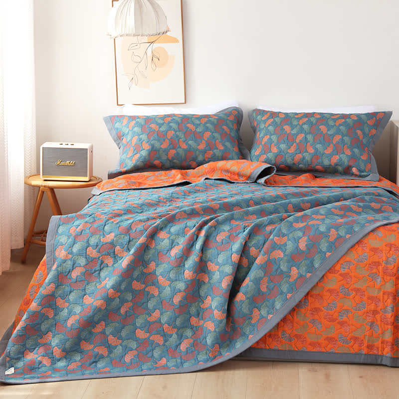 Ginkgo leaf quilt on a bed with the orange leaf reverse turned back along one side