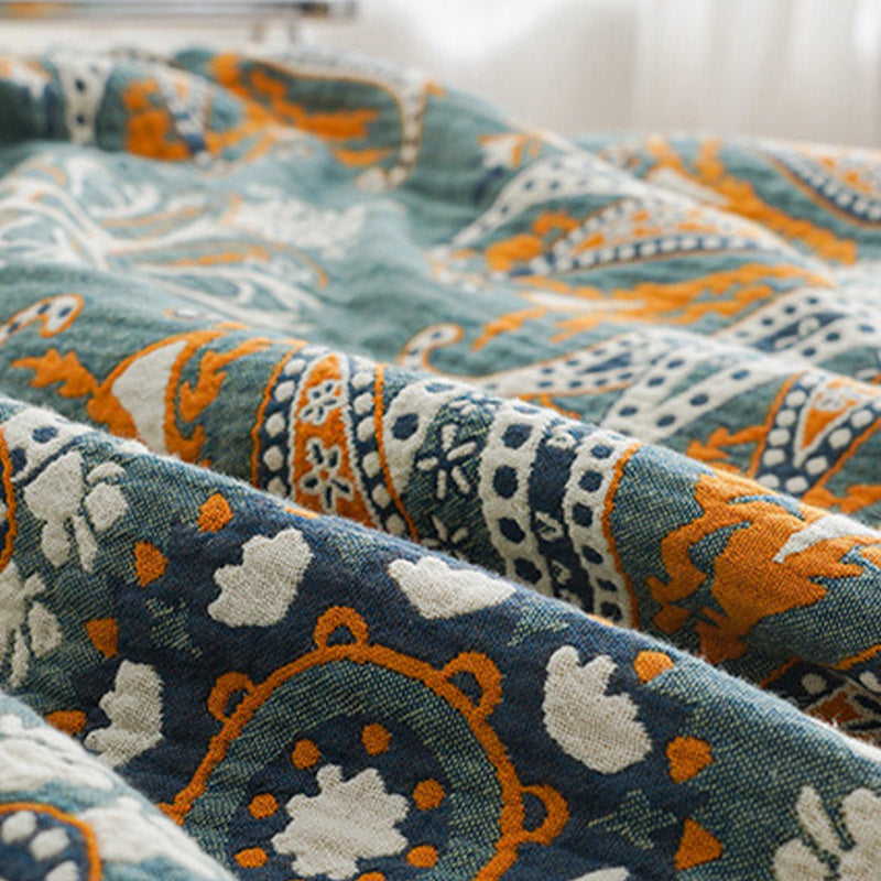 Close-up of the woven cotton, paisley bands in orange, navy and white with small white flowers on dark teal