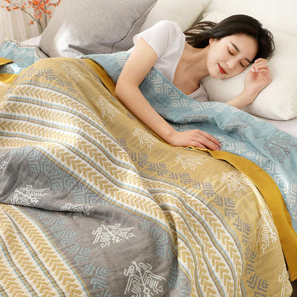 Woman asleep under the striped cotton quilt, its aqua reverse folded over her shoulder