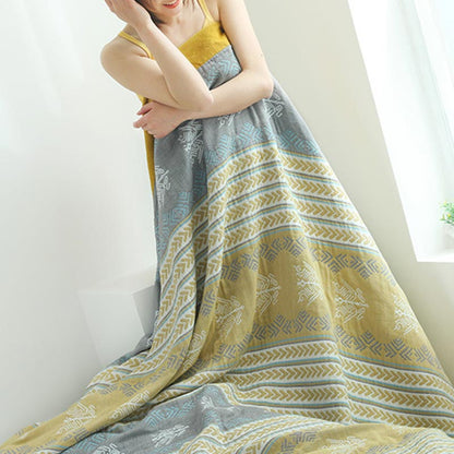 Cotton quilt wrapped around a woman's shoulders and falling in loose folds, gray and gold bands showing