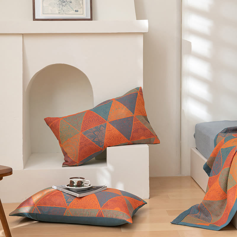 Two matching pillowcases in the orange and blue triangle pattern