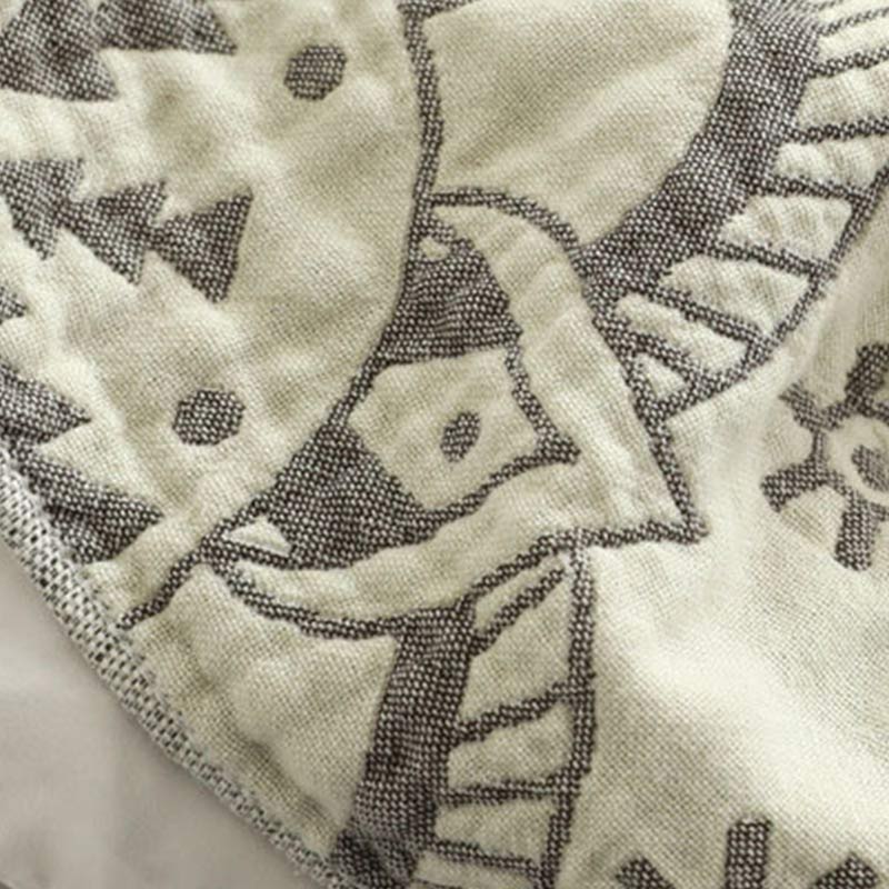 Close-up of the gray pattern woven into the cream cotton, the dark gray reverse showing at the fold