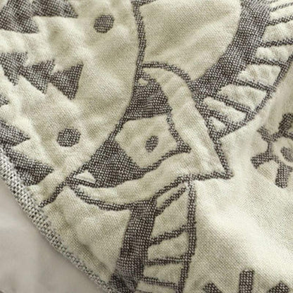 Close-up of the gray pattern woven into the cream cotton, the dark gray reverse showing at the fold