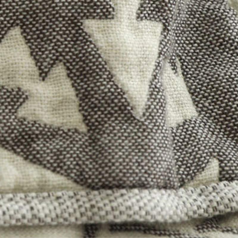 Macro of the woven cotton, gray yarns forming the zigzag and a narrow gray and cream edge below