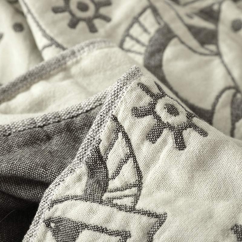 Folded edge of the gray quilt showing the cream face and the dark gray reverse side by side