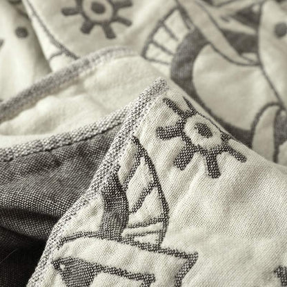Folded edge of the gray quilt showing the cream face and the dark gray reverse side by side