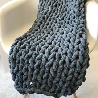 Slate blue-gray chunky chenille throw draped over a white molded chair