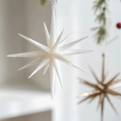 Large white glitter star ornament with a champagne starburst hanging behind it