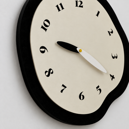 Close view of the clock's cream face raised on its matte black frame, with tilted serif numerals and leaf-shaped hands