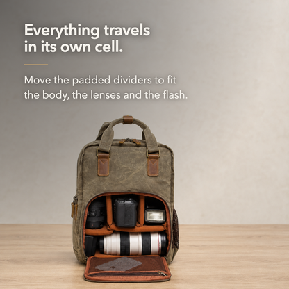 Camera backpack open on a table with a body, two lenses and a flash in padded cells.