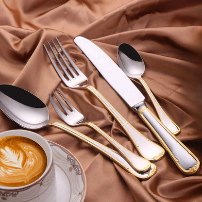 Gold trim flatware on brown satin beside a cup of coffee