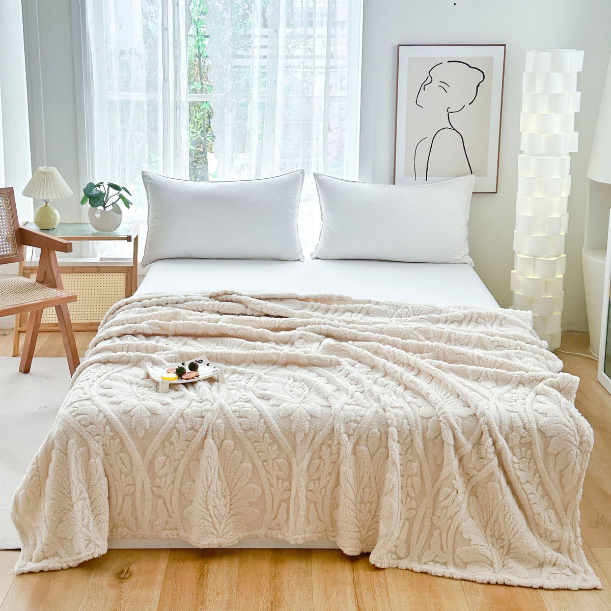 Ivory embossed fleece blanket over a bed with a snack tray on top